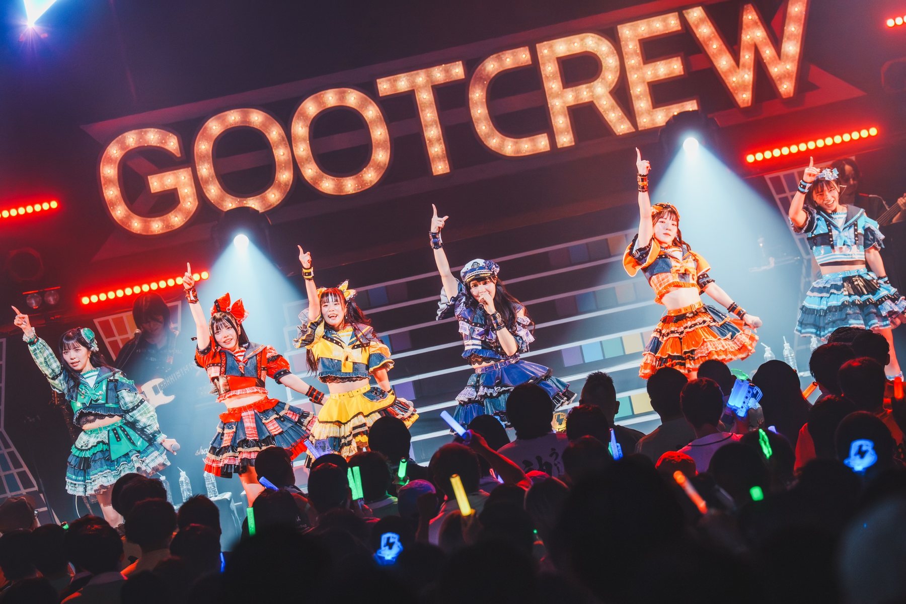 GOOTCREWのロゴの前でパフォーマンスするメンバー